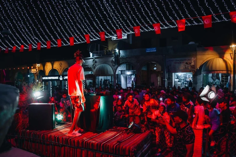A crowd in front of the DJ booth during a live performance